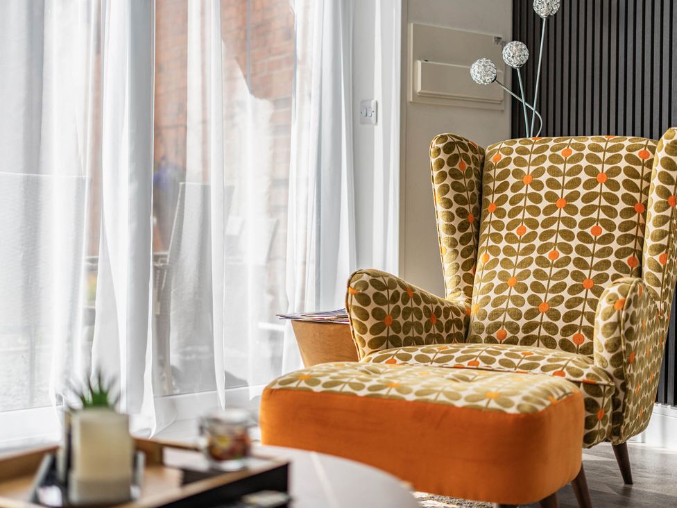 A chair and curtains in a living room at Captivating 2 Bed House in Nettleham