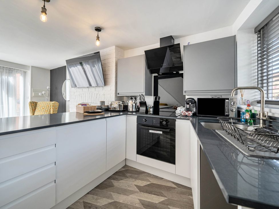 A kitchen with appliances and a countertop at Captivating 2 Bed House in Nettleham