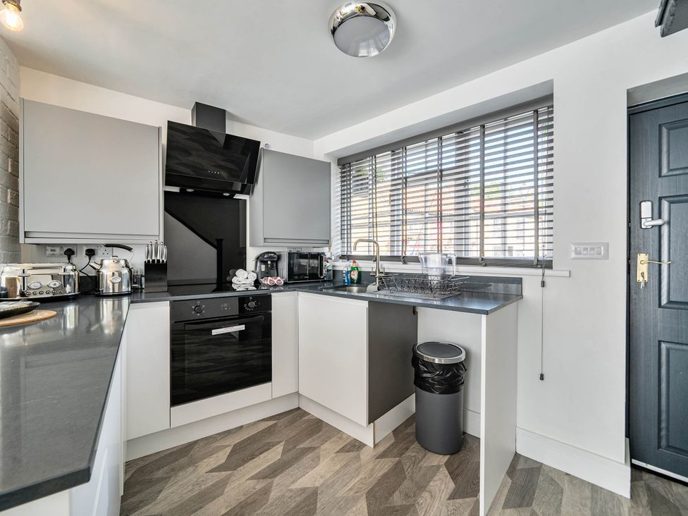 A kitchen with appliances and sink at Captivating 2 Bed House in Nettleham