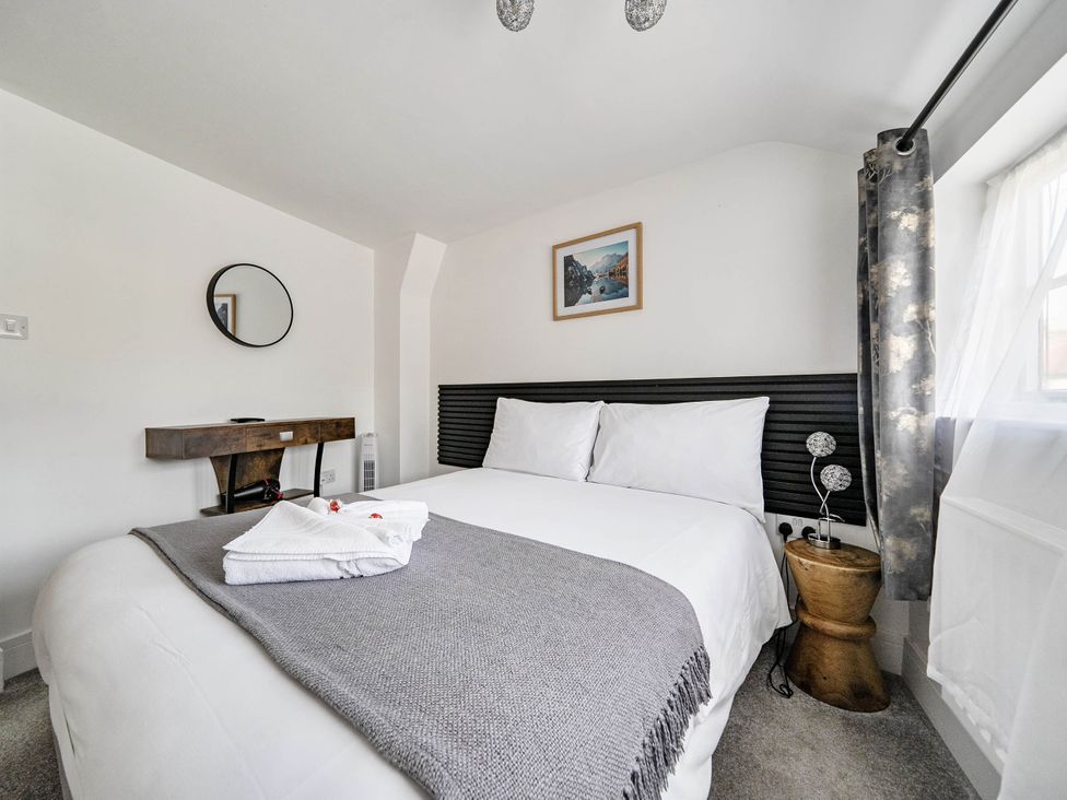A bedroom with a bed and bedside table at Captivating 2 Bed House in Nettleham