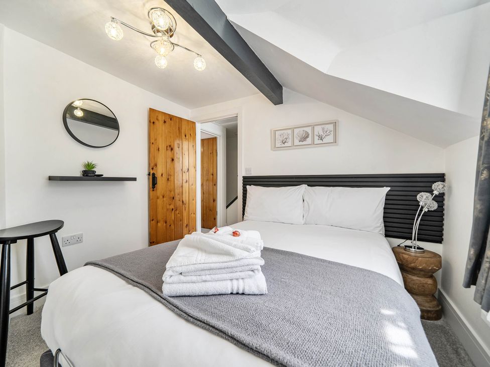 A bedroom with a bed and a mirror at Captivating 2 Bed House in Nettleham