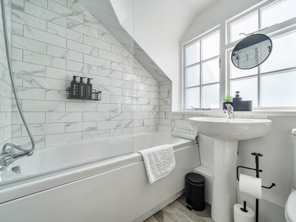 A bathroom featuring a bathtub, sink, and shower at Captivating 2 Bed House in Nettleham