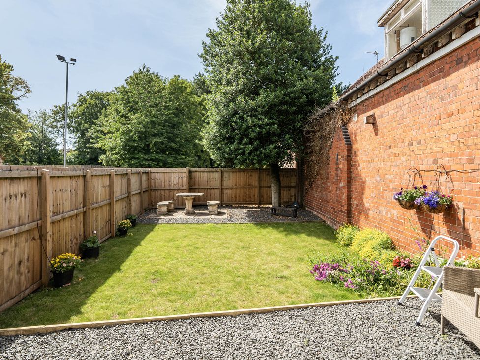 A garden with a table and chairs surrounded by grass at Captivating 2 Bed House in Nettleham