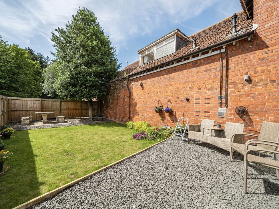 A garden with a table and chairs near a tree at Captivating 2 Bed House in Nettleham