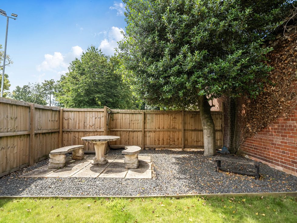 A garden with a stone table and bench at Captivating 2 Bed House in Nettleham