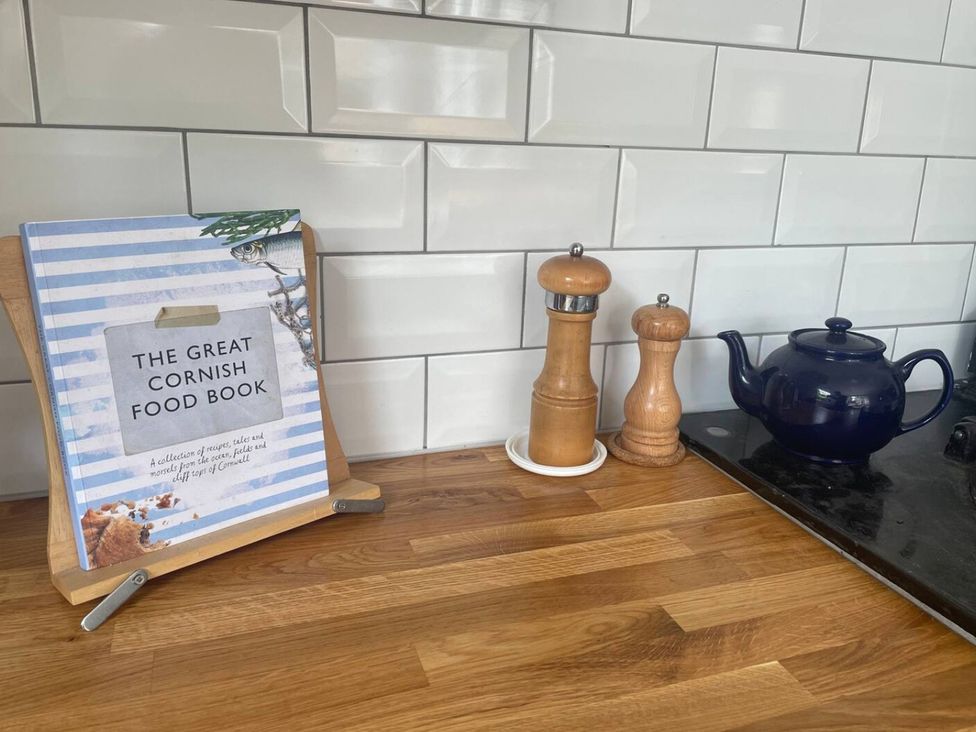 A kitchen counter with a cookbook, pepper mill, salt shaker and teapot at The Old Barn near St Ives Rustic Charm Space Lelant