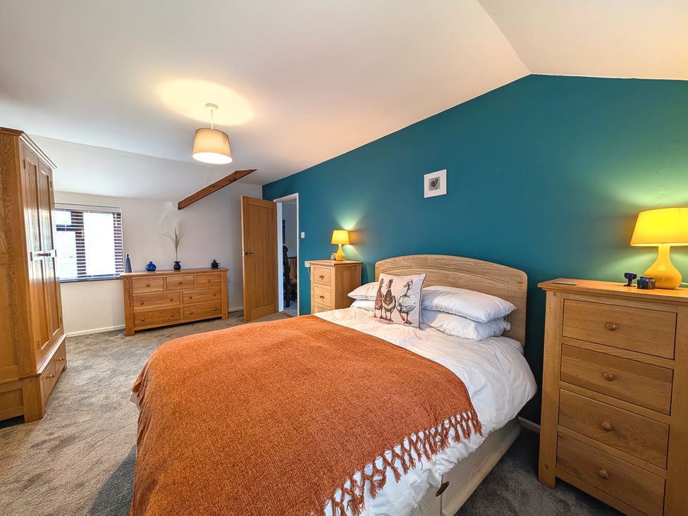 A bedroom with a bed and wooden furniture at The Old Barn near St Ives Rustic Charm Space, Lelant