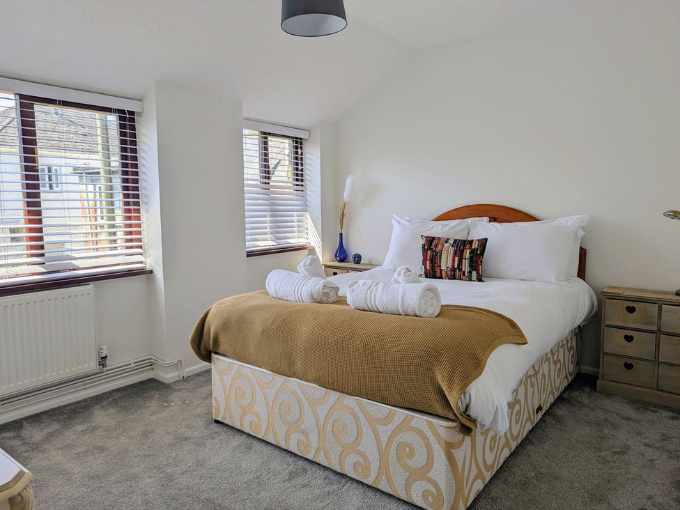A bedroom with a bed and windows at The Old Barn near St Ives Rustic Charm Space Lelant