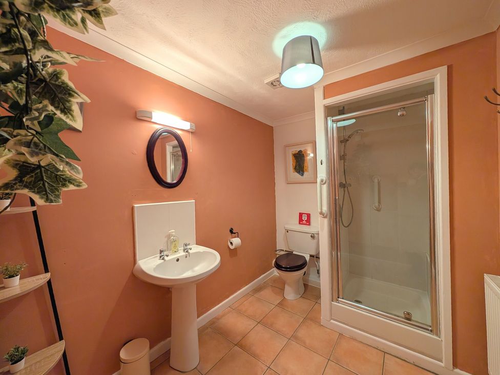 A bathroom with a sink, toilet, and shower at The Old Barn near St Ives Rustic Charm Space in Lelant