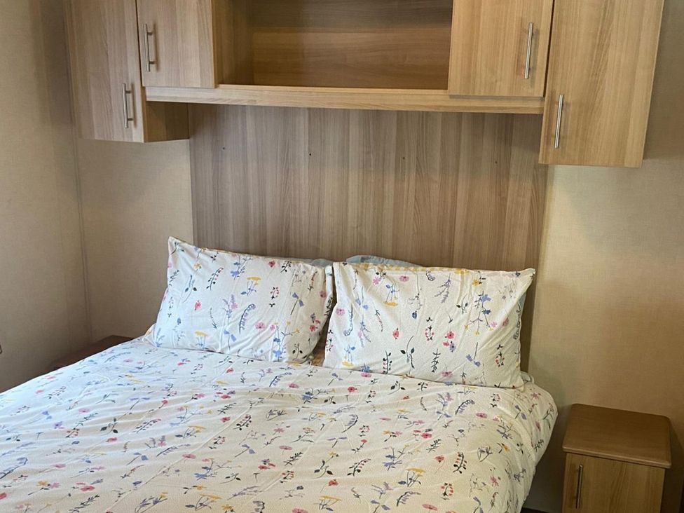 A bed with pillows and a nightstand at the property in 