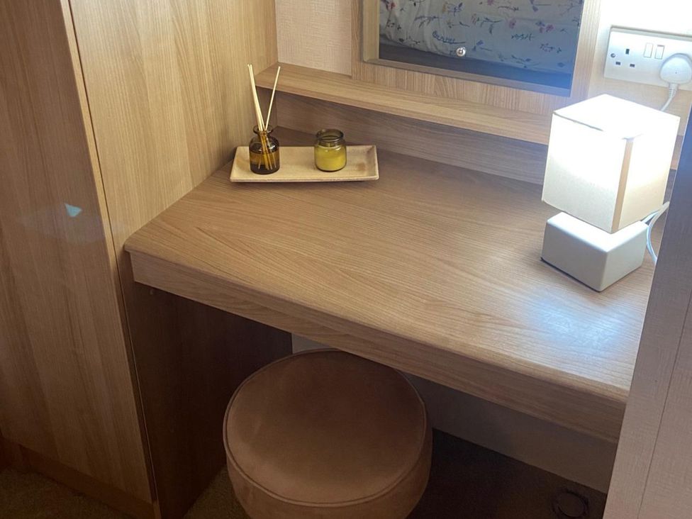A desk with a lamp and scented oil in a dressing room at 