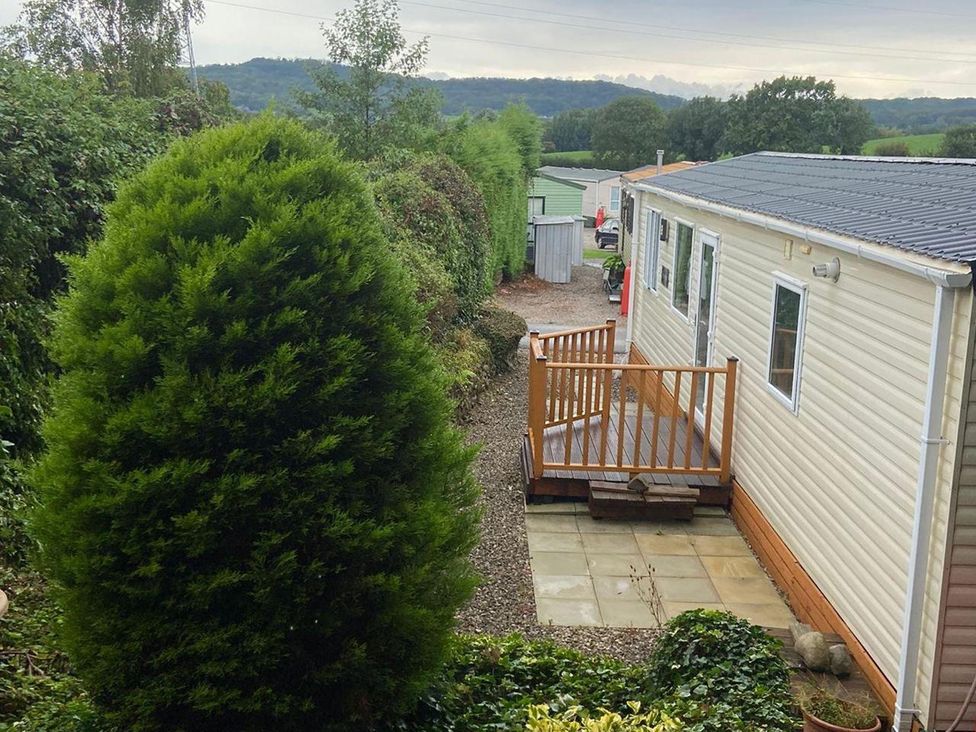 An outdoor area with a deck and mobile home at a campsite in an unknown location