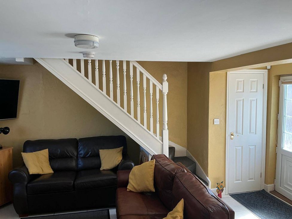A living room with a sofa and stairs in a property