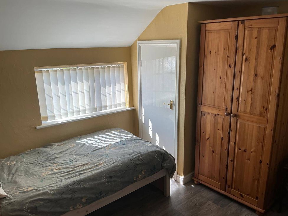 A bedroom with a bed and a wardrobe at The Old Barn in Manchester