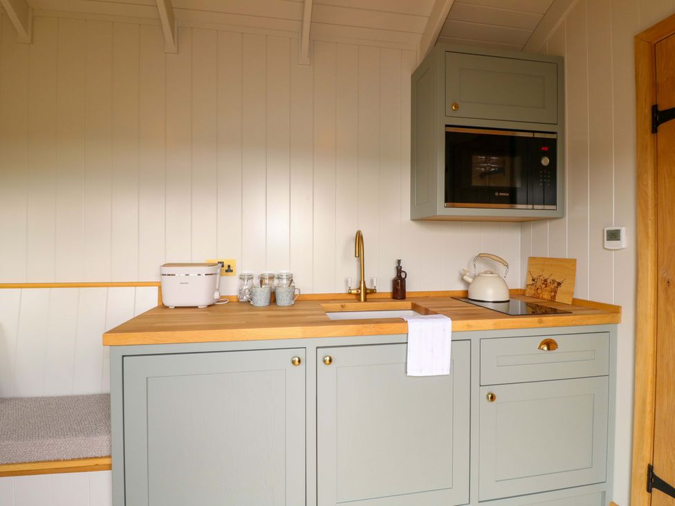 A kitchen with sink and microwave at Pike House Farm Shepherds Hut 1 Asbourne