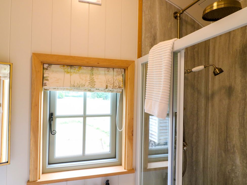 A bathroom with a window and shower at Pike House Farm Shepherds Hut 1 Asbourne