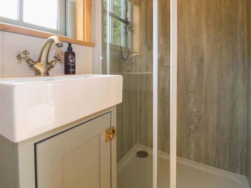 A sink and shower area at Pike House Farm Shepherds Hut 1 Asbourne