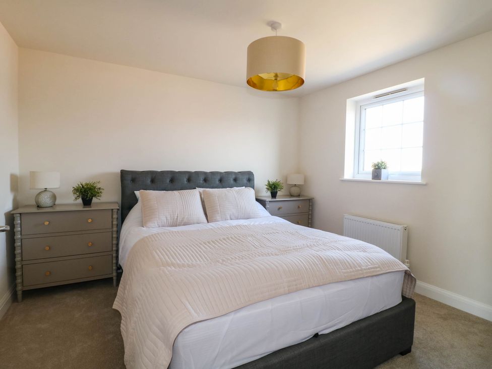 A bedroom with a bed and bedside tables at No.6 Beck Crescent in Ashbourne
