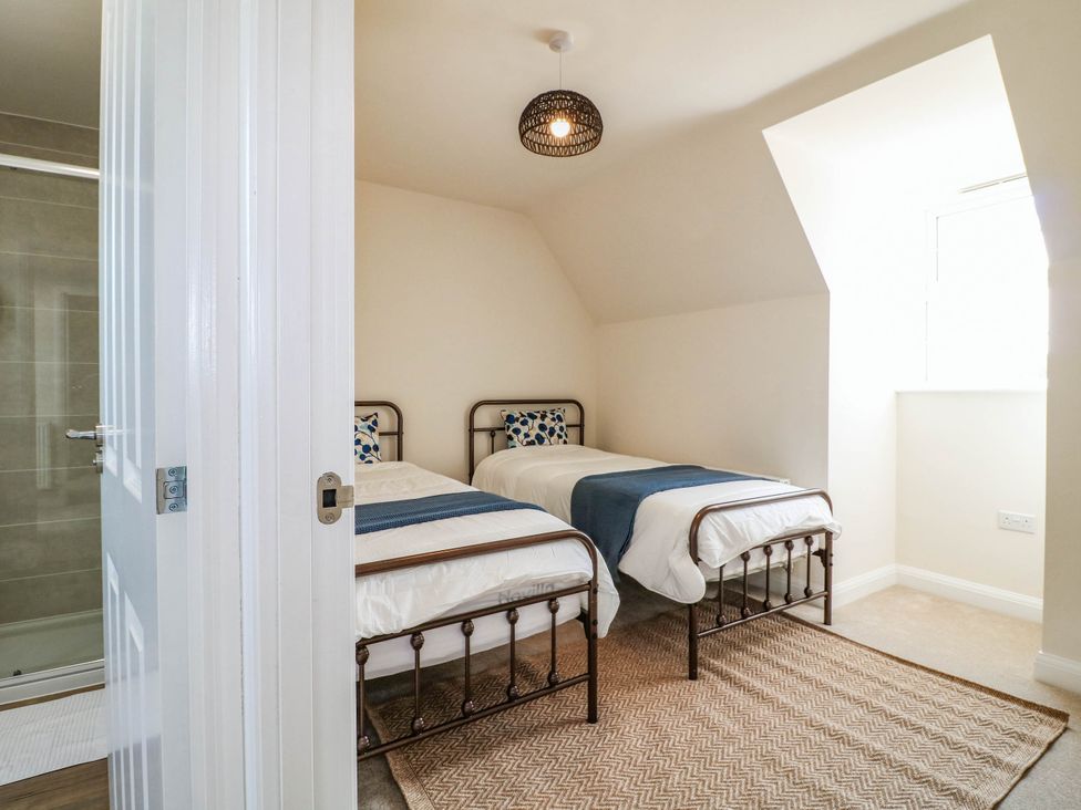 A bedroom with twin beds and a window at No.6 Beck Crescent Ashbourne