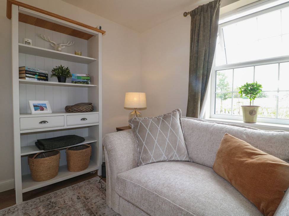 A living room with a sofa, shelves, and a lamp at No.6 Beck Crescent in Ashbourne