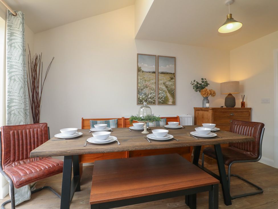 A dining room with a wooden table and chairs at No.6 Beck Crescent in Ashbourne