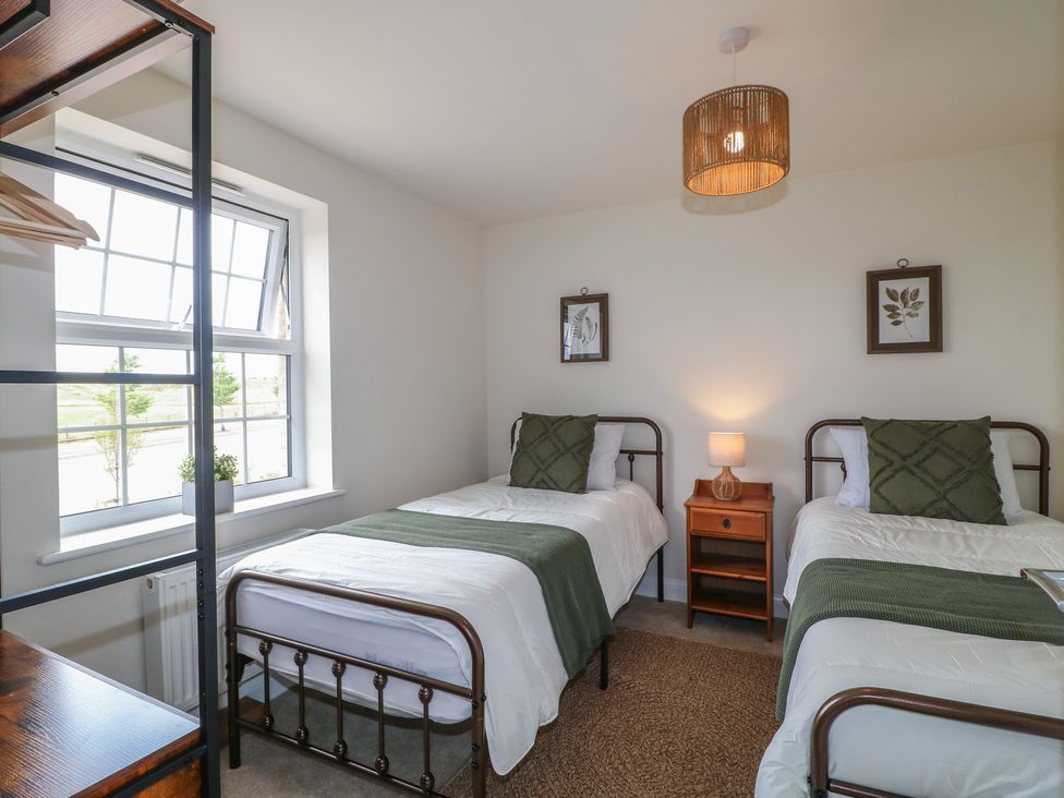 A bedroom with two beds and a nightstand at No.6 Beck Crescent Ashbourne