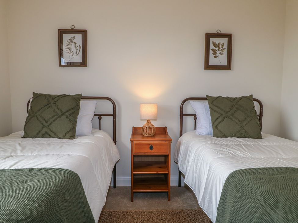 A bedroom with two single beds and a nightstand at No.6 Beck Crescent Ashbourne