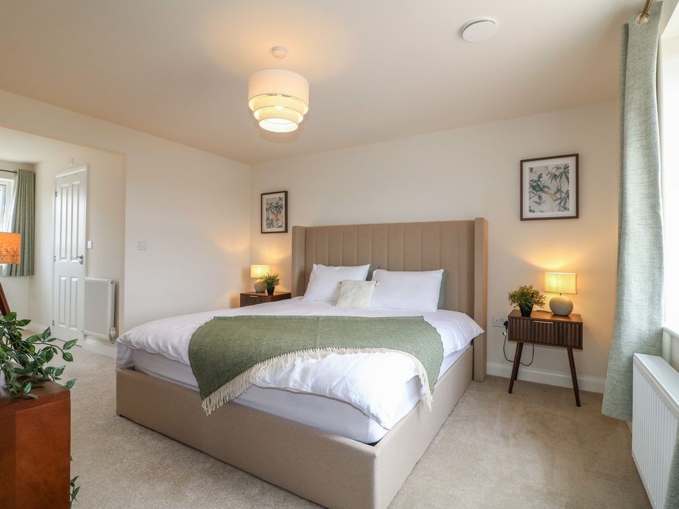 A bedroom with a bed and nightstands at No.6 Beck Crescent Ashbourne