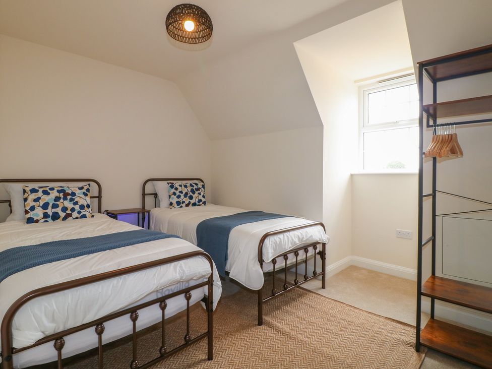 A bedroom with two beds and a shelf at No.6 Beck Crescent Ashbourne
