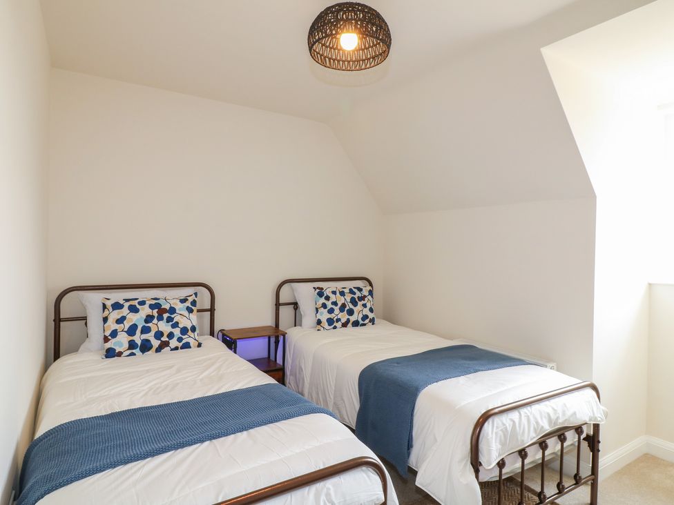 A bedroom with two beds and a bedside table at No.6 Beck Crescent Ashbourne