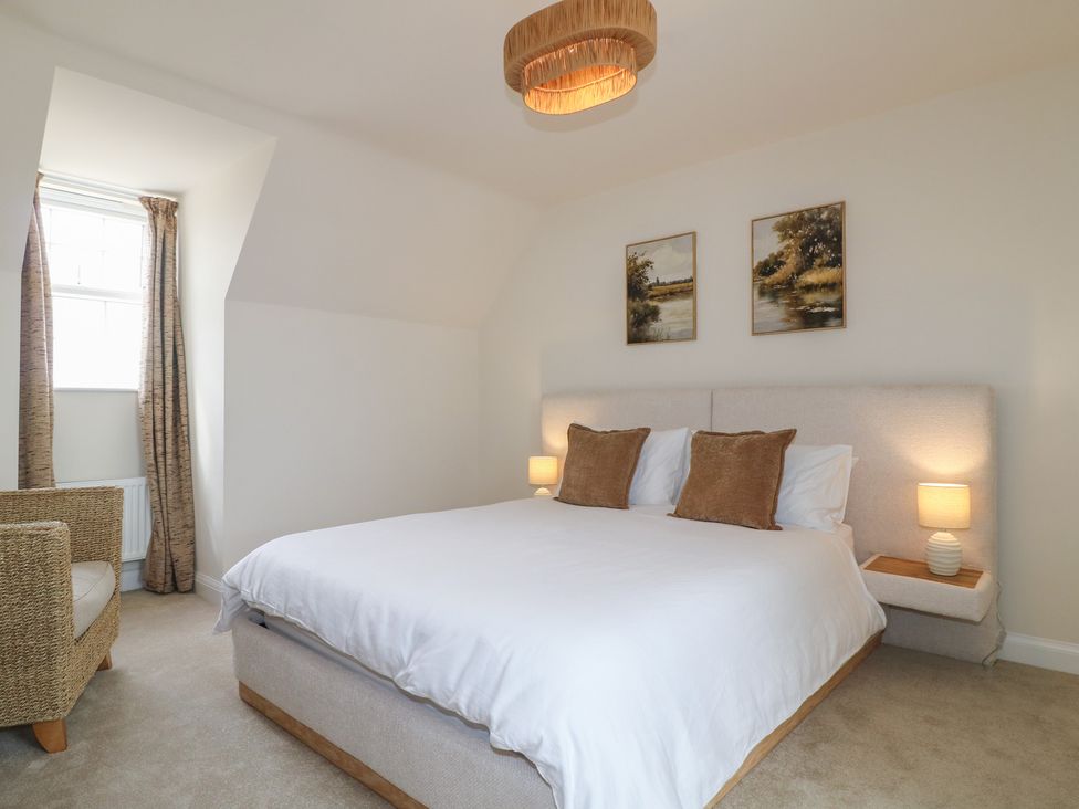 A bedroom with a bed and chair at No.6 Beck Crescent Ashbourne