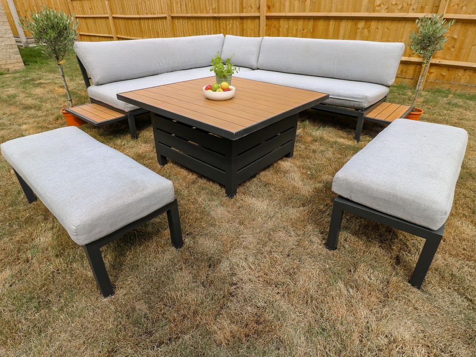 A garden with an outdoor sofa and a coffee table at No.6 Beck Crescent Ashbourne