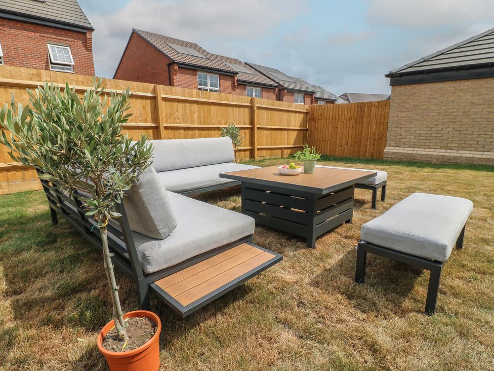A garden with a seating area and a coffee table at No.6 Beck Crescent in Ashbourne