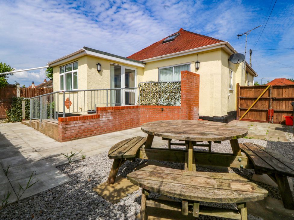 A garden with a picnic table and house at Seaside Bungalow in Rhyl