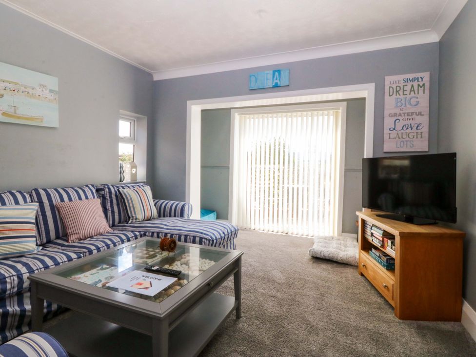 A living room with a couch and television at Seaside Bungalow in Rhyl