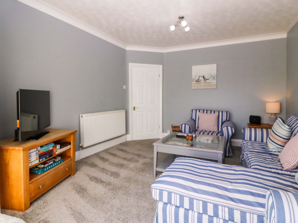 A living room with a television and sofa at Seaside Bungalow in Rhyl