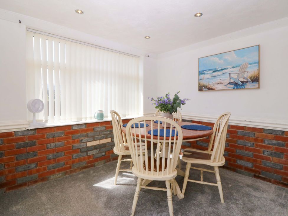 A dining room with a table and chairs at Seaside Bungalow in Rhyl