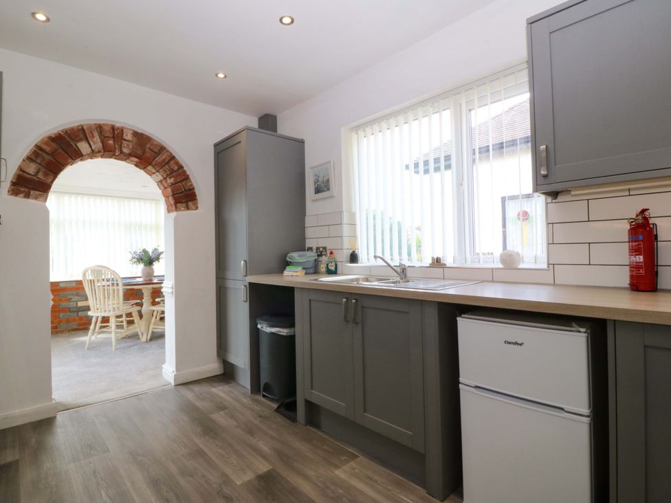 A kitchen with a sink and fridge at Seaside Bungalow in Rhyl