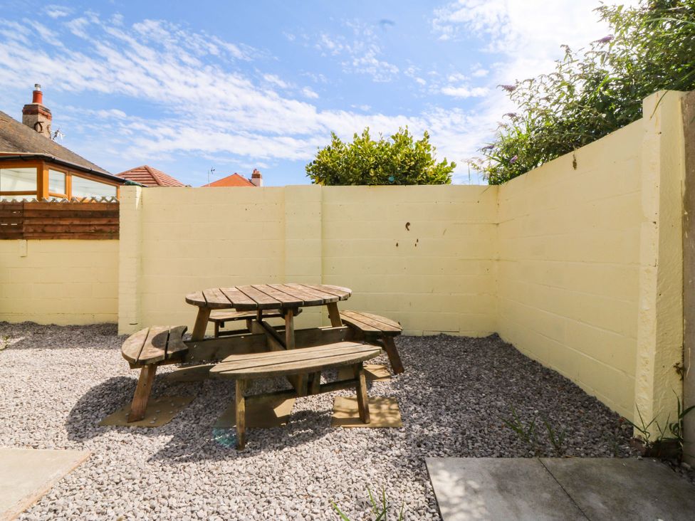 A garden with a table and benches at Seaside Bungalow in Rhyl