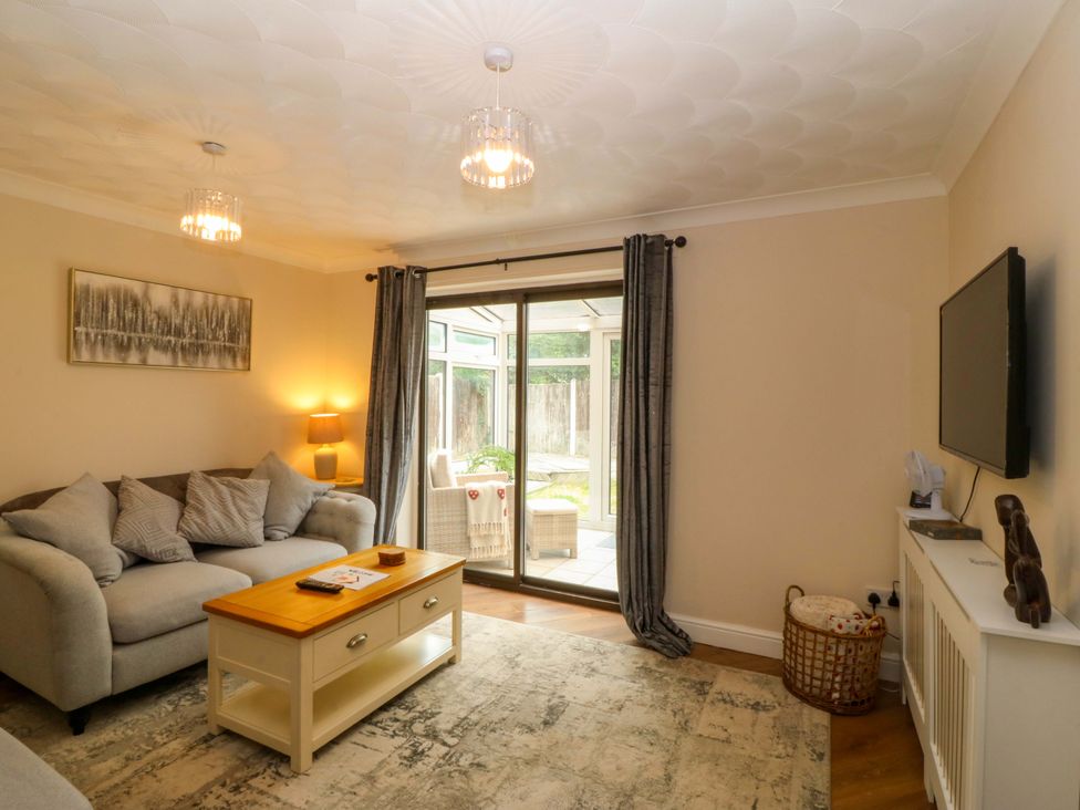 A living room with a sofa and television at Robins Nest in Rhyl