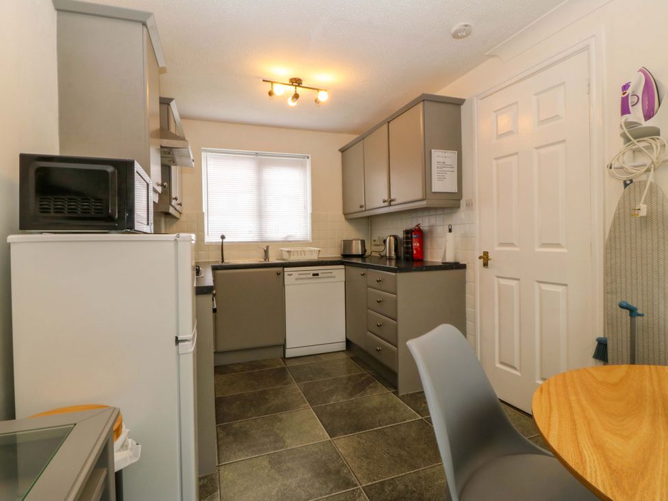 A kitchen with appliances and a table at Robins Nest in Rhyl