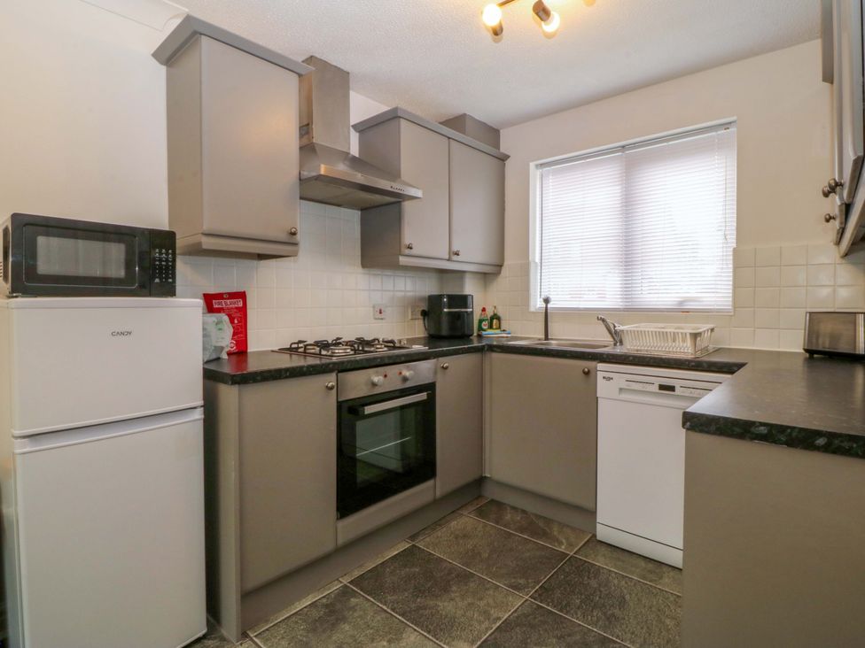 A kitchen with appliances and cabinets at Robins Nest in Rhyl