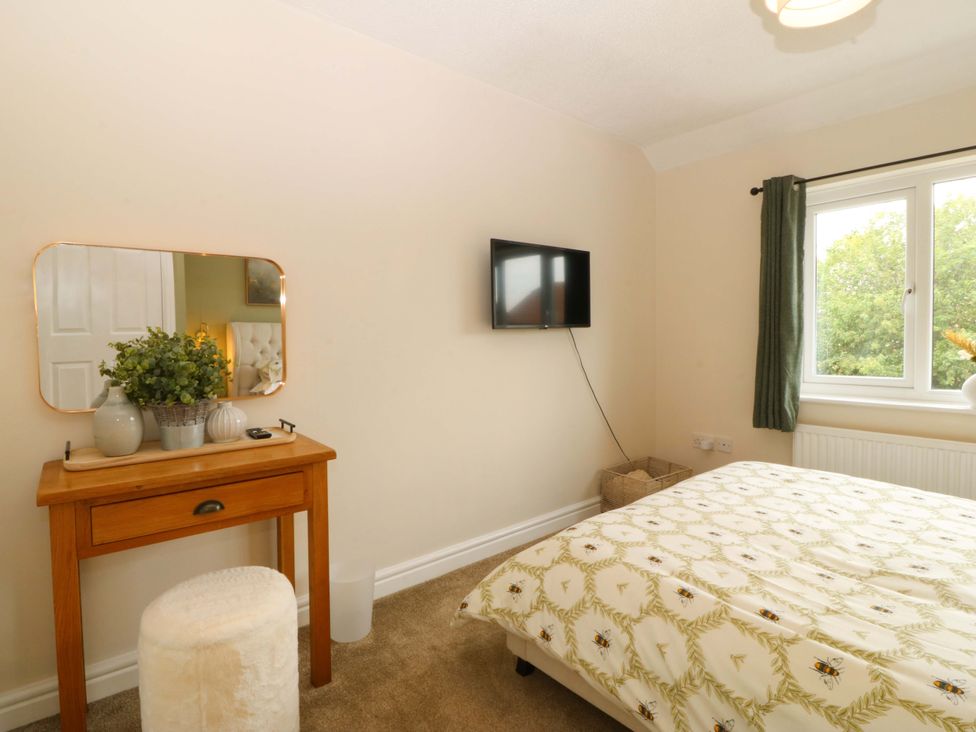 A bedroom with a bed and mirror at Robins Nest in Rhyl
