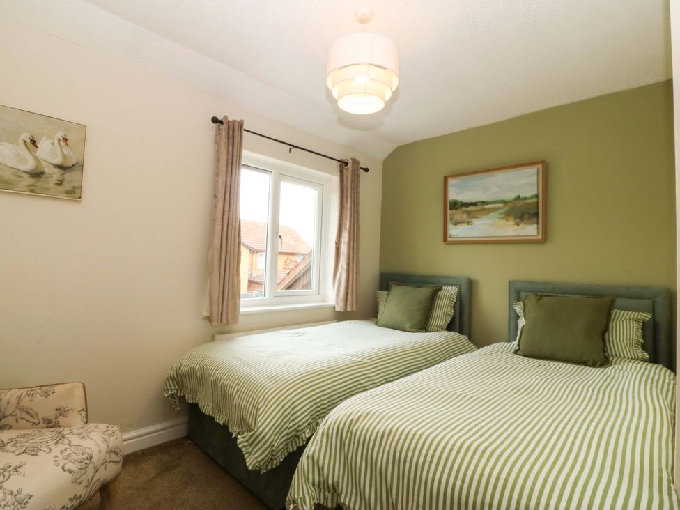 A bedroom with two beds and a window at Robins Nest in Rhyl