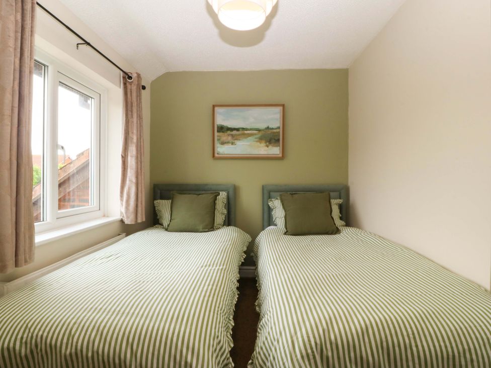 A bedroom with two beds and a window at Robins Nest in Rhyl