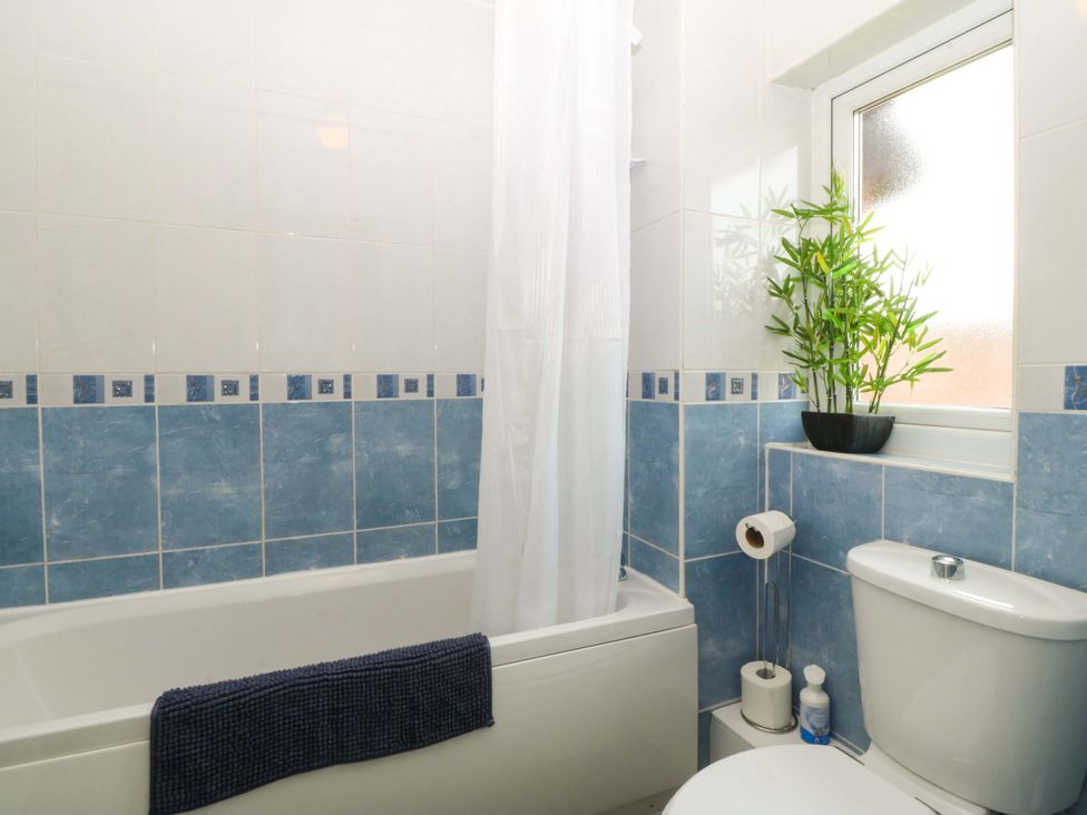 A bathroom with a bathtub and toilet at Robins Nest in Rhyl