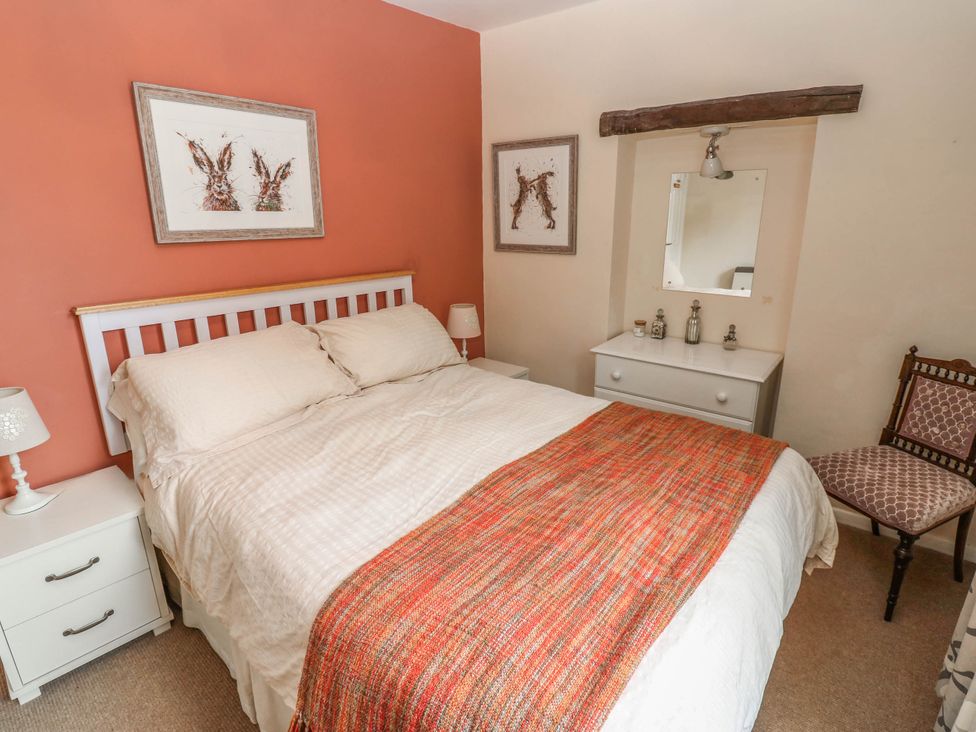 A bedroom with a bed and nightstand at Kernot Cottage in Reeth