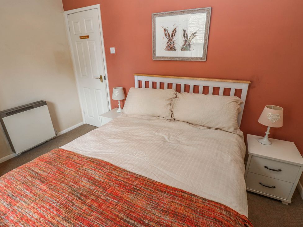 A bedroom with a bed and bedside tables at Kernot Cottage in Reeth