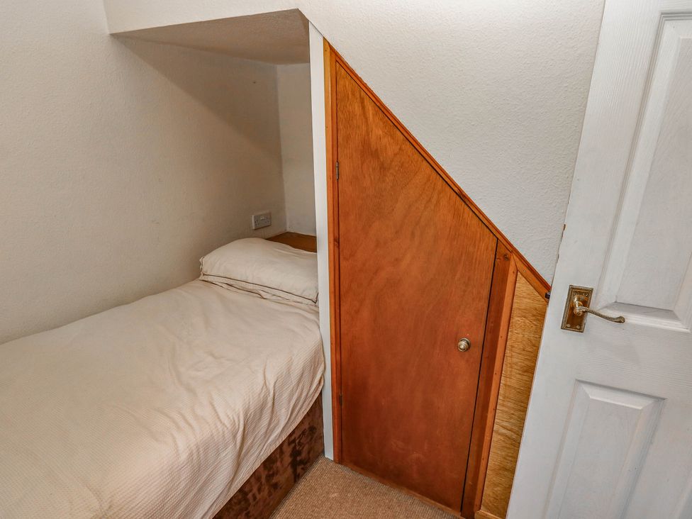 A bedroom with a bed and a door at Kernot Cottage in Reeth