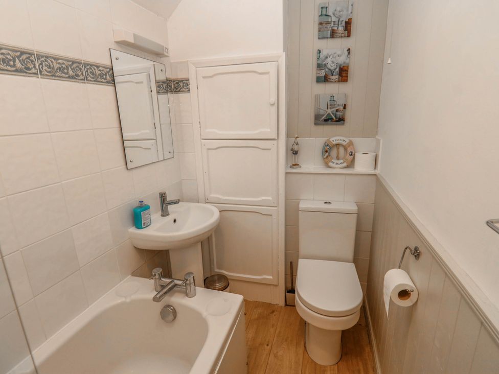 A bathroom with a bath tub, sink, and toilet at Kernot Cottage in Reeth